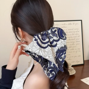 Oversized paisley pattern silk scrunchie for women holding a ponytail in a retro style