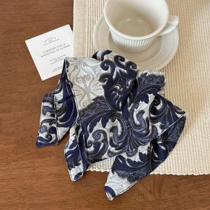 Macro view of blue baroque silk scarf with intricate vine patterns and scroll motifs