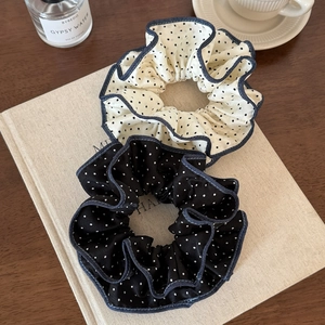 Black and white polka dot scrunchie set with wave edge overlock on a coffee table