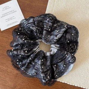 Detail shot of black lace and gray satin hair scrunchie with silver pearl embellishments