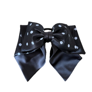 Elegant black and white polka dot satin bow hair clip with a smooth glossy finish