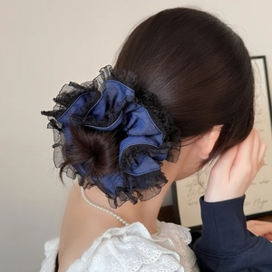 Chouchou élégant en denim bleu marine avec bordure en dentelle noire porté par un modèle