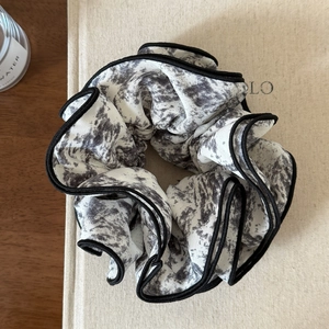 Close-up of vintage black and white ink wash scrunchie with contrast piping and soft texture