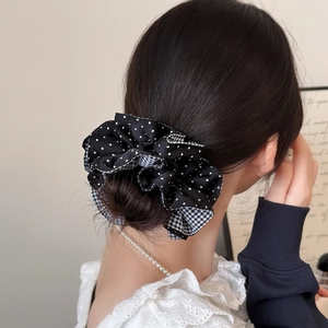 Large checkered and polka dot fabric scrunchie worn on hair bun for a stylish look