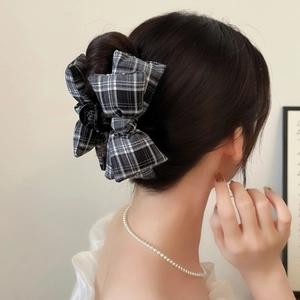 Eleganter schwarz-weißer Haarkrebs mit Karomuster und Schleife, getragen an einem Dutt