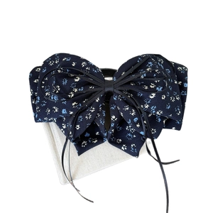 Elegant navy blue floral bow hair clip for ponytail styling with premium fabric texture