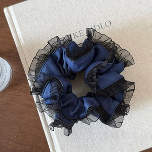 Gros plan détaillé du chouchou texture denim bleu foncé avec bordure en dentelle noire