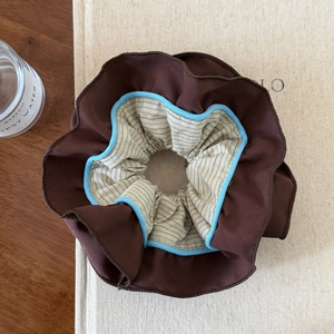 Vue détaillée du chouchou rayé à plusieurs couches en tissu marron et bleu texturé