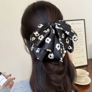Pince à cheveux avec grand nœud floral et perles sur tissu en satin noir