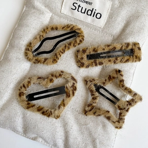 Close-up of plush leopard print hair clips set in heart, star, and geometric shapes