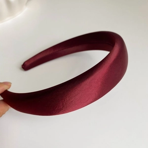 Détail de serre-tête en satin bordeaux épais avec texture soyeuse et rembourrage élégant