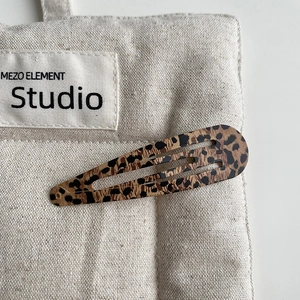 Close-up of leopard print metal snap hair clip with a vintage and stylish finish