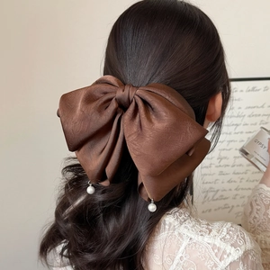 Barrette à cheveux élégante en satin marron avec perles blanches sur cheveux ondulés