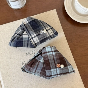 Close-up of triangle hair clips with plaid fabric texture, pearl and button details