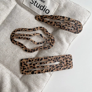 Detailed view of leopard print hair clips in teardrop, wavy, and rectangular shapes
