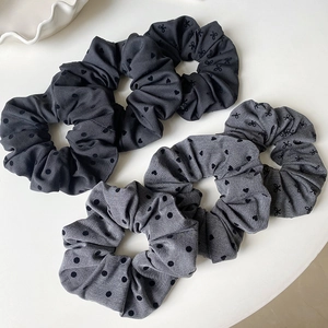 Detail von grauen Haargummis mit Punkten und Herzmuster aus weichem Stoff