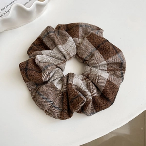 Detailed view of the brown and beige plaid fabric texture of the large scrunchie