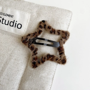 Close-up of leopard print plush star hair clip with soft faux fur texture and metal snap