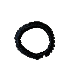 Minimalist black seamless pleated hair tie with a spiral telephone cord elastic design