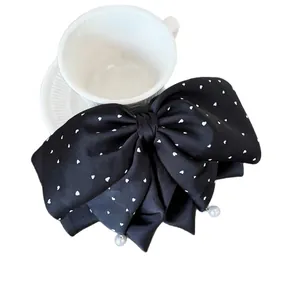 Grande pince à cheveux nœud en satin noir avec motifs cœurs et perles élégantes
