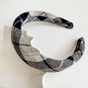 Detailed close-up of a plaid velvet headband with grey and purple checkered fabric texture