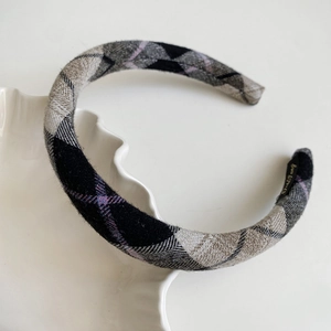 Close-up of a plaid flannel headband with grey and black check pattern texture