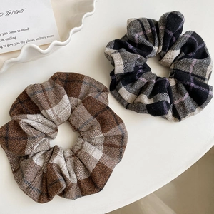 Macro view of brown and purple plaid hair scrunchies in textured autumn wool fabric