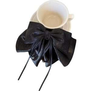 Elegant black satin bow hair claw with shimmering fabric and long ribbons for women