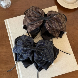 Close-up of vintage plaid bow hair clips with satin ribbon and delicate white pearl edges