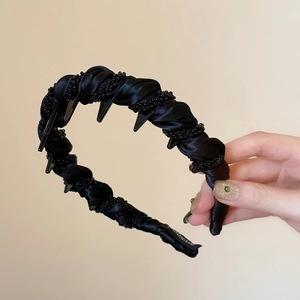 Détail d'un serre-tête en satin noir fait main avec perles et dents intérieures antidérapantes