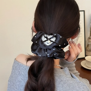 Chouchou élégant en satin noir à pois avec cœur en dentelle et perle sur modèle