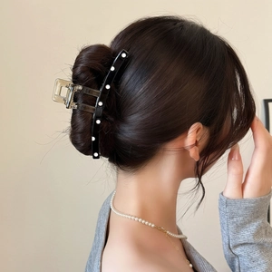 Elegant large black and white polka dot hair claw clip for bun hairstyles on a woman