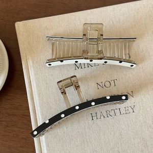 Detail of vintage polka dot hair claws in black and white on linen book cover