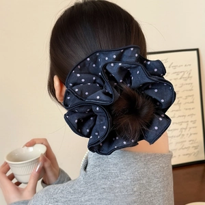 Navy blue polka dot scrunchie styled on a classic bun hairstyle for a vintage look