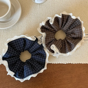 Chouchous à carreaux et dentelle bleu marine et marron sur un set de table