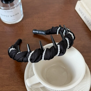 Serre-tête fait main en satin noir avec perles et dents, sur une tasse à café blanche