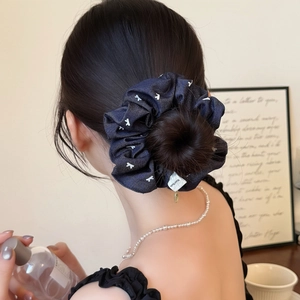 Navy blue denim scrunchie with white dots and hand made label worn by a female model