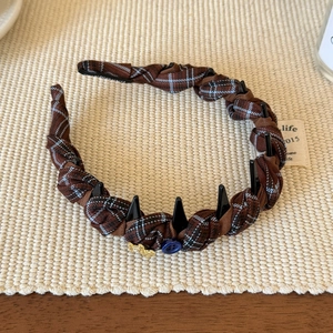 Détail d'un serre-tête en tissu à carreaux avec tresse et pendentif étoile dorée