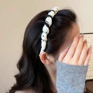 Chic black and white polka dot twisted headband with elegant pearl trim for women