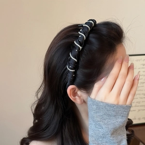 Close-up of black satin twisted headband with white faux pearl wrap on a female model