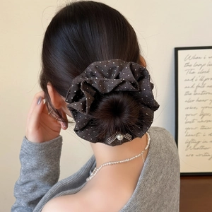 Chouchou à pois avec nœud perlé sur une coiffure en chignon élégante vue de derrière
