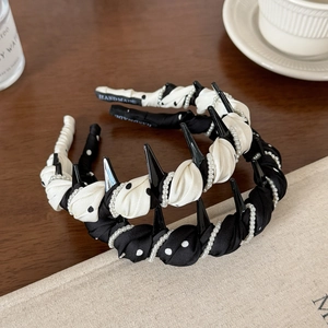 Detail of handmade polka dot headbands with pearl chain and anti-slip teeth on wood table