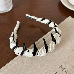 Detailed macro view of handmade headband with elegant pearls and polka dot fabric texture