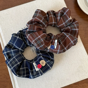 Plaid scrunchie set in brown and navy with decorative buttons and woven labels