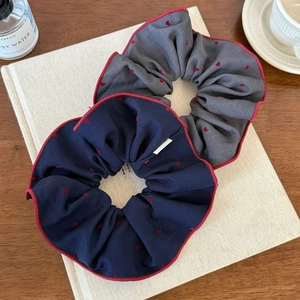 Navy blue and grey fabric scrunchies with red heart patterns and wavy edges