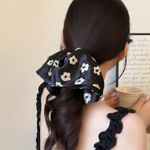 Elegant black satin floral scrunchie with pearl pendant shown on ponytail hair