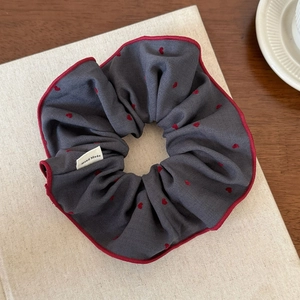 Detail of navy blue hair scrunchie with red heart print and Hand Made label