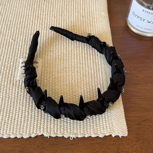 Détail du serre-tête en tissu noir avec strass et dents antidérapantes internes