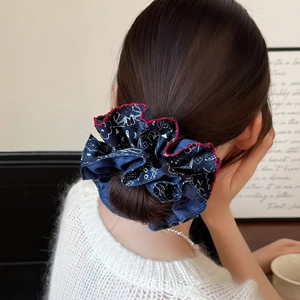 Blue paisley scrunchie with red ruffled edges worn in a stylish high ponytail for women