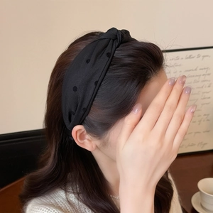 Diadema negra con nudo y lunares para mujer mostrada en un ambiente de estilo vida
